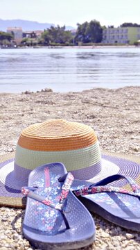 Vacation on sea beach with sandals and women hat on sand