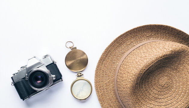 Flat Lay of Vintage Camera, Straw Travel Hat, and Classic Compass on White Background for Adventure and Exploration Concept