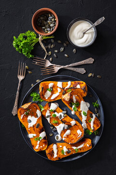 Baked butternut squash halves with yogurt sauce