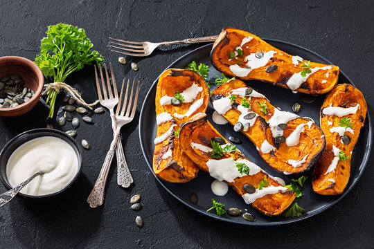 Baked butternut squash halves with yogurt sauce