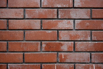 Fototapeta premium Texture of a weathered red brick wall with white paint stains and splatters forming a grunge architectural background