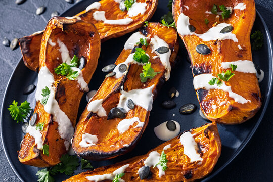 Baked butternut squash halves with yogurt sauce