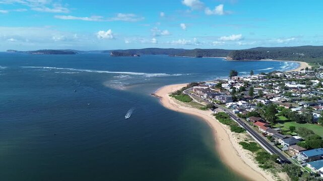 drone view Ettalong beach NSW Australia.View of the bay with boats and a town by the water on a sunny day near a large hill in New South Wales