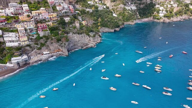 Aerial Drone Side View of Positano Village with Rocky Cliffs, Beach and Boats on Turquoise Sea, Amalfi Coast Italy Summer