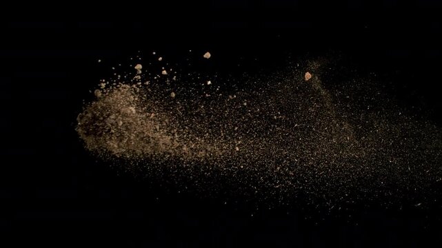 Super Slow Motion Shot Flying Soil Isolated on Black at 1000fps.