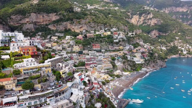 Aerial Drone Low View of Positano with Chiesa Santa Maria Assunta, Colourful Buildings, Beach and Blue Sea, Amalfi Coast Italy Summer