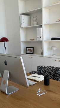 Aesthetic workspace view featuring a computer, wooden desk, and a zebra-print chair.