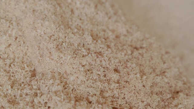 Close-up of a pile of fine natural wood sawdust with soft texture and warm beige tones. Ideal as a woodworking, carpentry, or biomass background with copy space