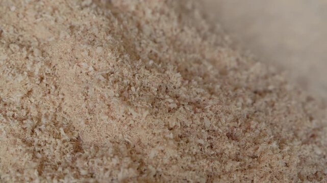 Close-up of a pile of fine natural wood sawdust with soft texture and warm beige tones. Ideal as a woodworking, carpentry, or biomass background with copy space