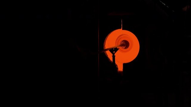 Artisan Shaping Molten Glass Inside a Glowing Furnace