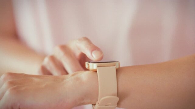 In home gym, girl checks her fitness watch, reading heart-rate and calorie numbers on wearable device. This health-monitoring scene underscores precise physical activity tracking and modern wellness
