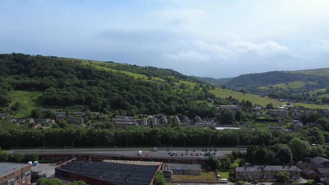 Aerial drone view of Mytholmroyd railway station in Calderdale West Yorkshire showing surrounding streets and hills