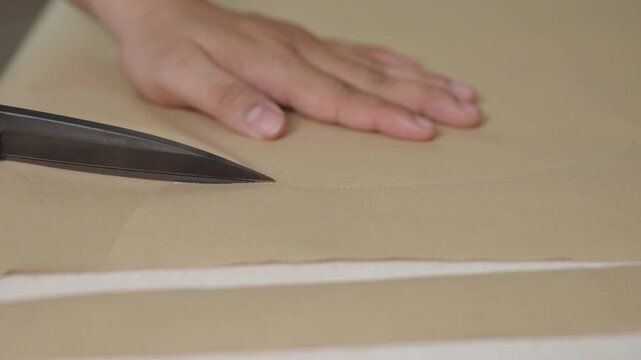 Close-up of cutting paper sewing pattern during wedding dress development