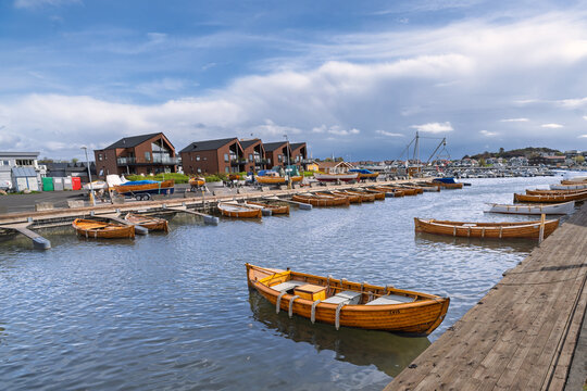Colorful Wooden Boats Docked at Coastal Harbor with Reflective Water and Sunny Sky, Stavern, Norway