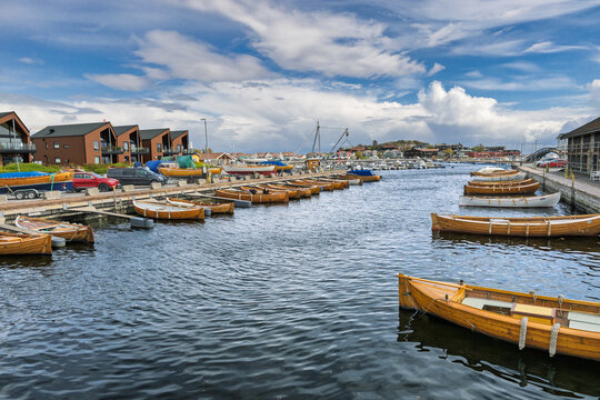 Colorful Wooden Boats Docked at Coastal Harbor with Reflective Water and Sunny Sky, Stavern, Norway