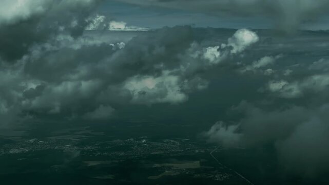 Dramatic cloudscape with ground view of a town below heavy overcast skies