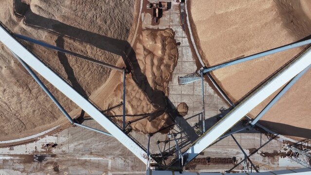 Aerial view of large grain silo with sand and gravel conveying operation in progress