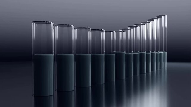 A sequence showing a line of glass cylinders where the dark liquid level in each tube rises and falls in a synchronized wave-like motion, set against a dark reflective studio background.