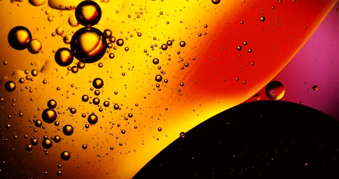 Abstract warm colored oil bubbles floating in water
