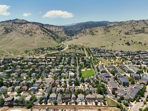 Aerial view of residential neighborhood near Fourmile Canyon Creek Trailhead with houses, green spaces, and mountain foothills in Boulder, Colorado, United States.