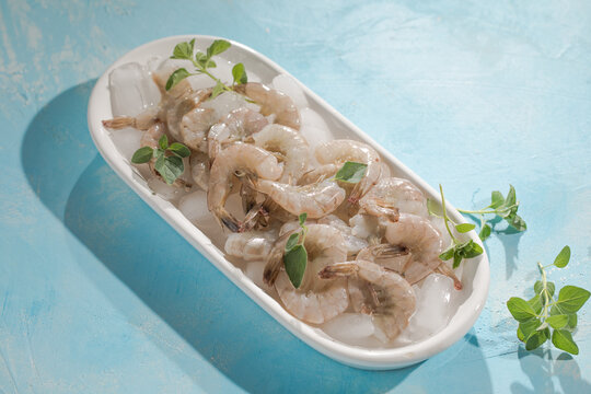Raw pacific white shrimp prawn peeled with tail on ice.Top view. Copy space.