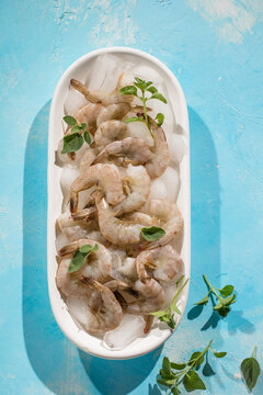 Raw pacific white shrimp prawn peeled with tail on ice.Top view. Copy space.