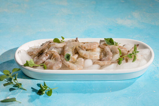 Raw pacific white shrimp prawn peeled with tail on ice.Top view. Copy space.