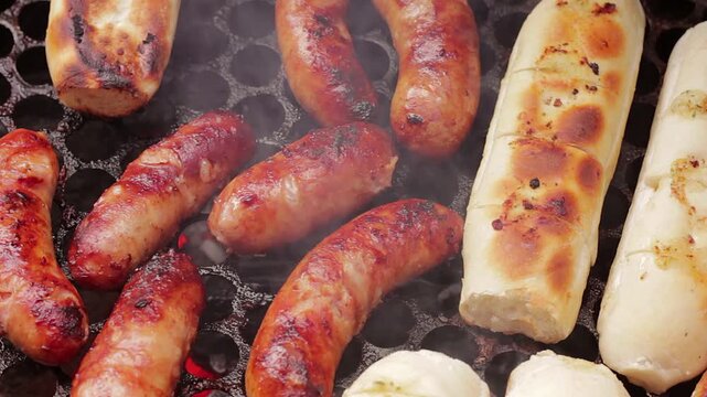 Sausages and garlic bread grilling on a hot barbecue, with visible smoke and grill marks