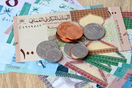 Omani rial money bills and coins on table. Oman cash of OMR currency close up