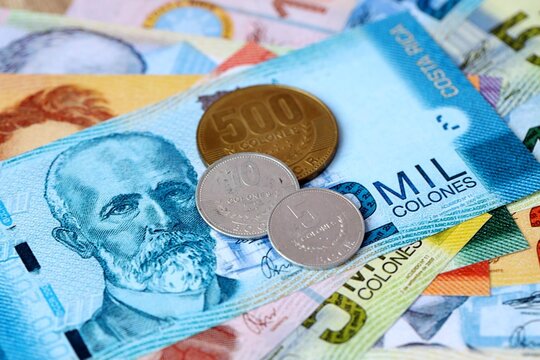 Costa Rican colon money bills and coins on table. Costa Rica cash of CRC currency close up