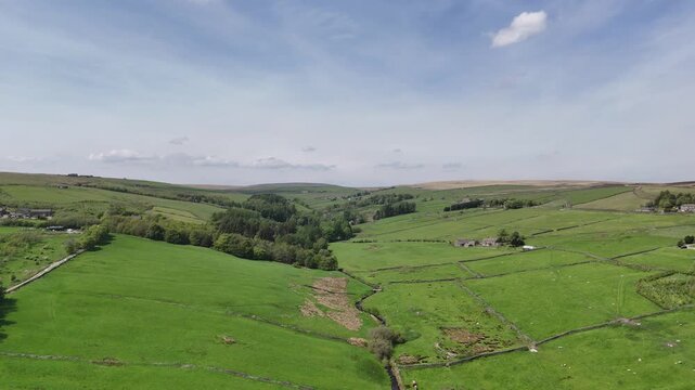 High aerial view of hebden water in Colden near heptonstall surrounded by grazing sheep in meadows and farmhouses in West Yorkshire landscape
