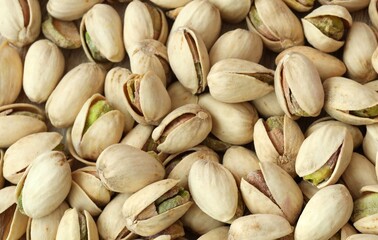 Fototapeta premium A photo of a pile of pistachios, with the majority still in their shells. Big amount of pistachios