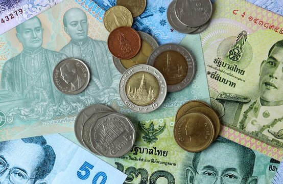 Thai baht money banknotes and coins on table. Thailand cash bills of THB currency