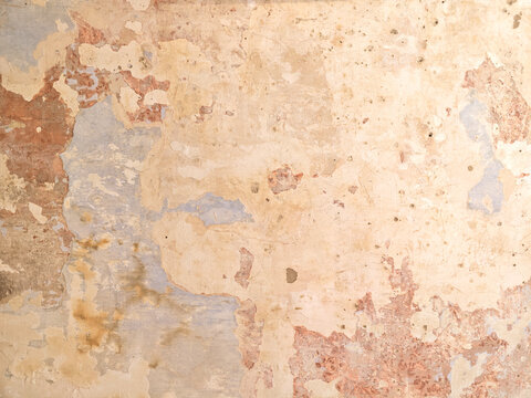 Old plaster wall showing peeling paint texture