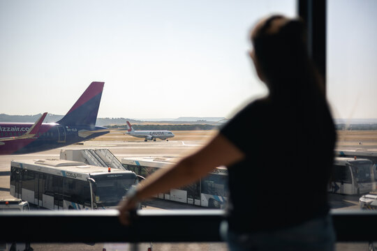 Traveler watching airplanes at Wizz Air and Lauda airport terminal, anticipating an upcoming journey or departure in Madrid, Spain - June 8, 2026