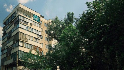 Modern apartment building surrounded by lush green trees in a residential neighborhood. Ideal for real estate, urban lifestyle, architecture, and eco-friendly city concepts. © Aida