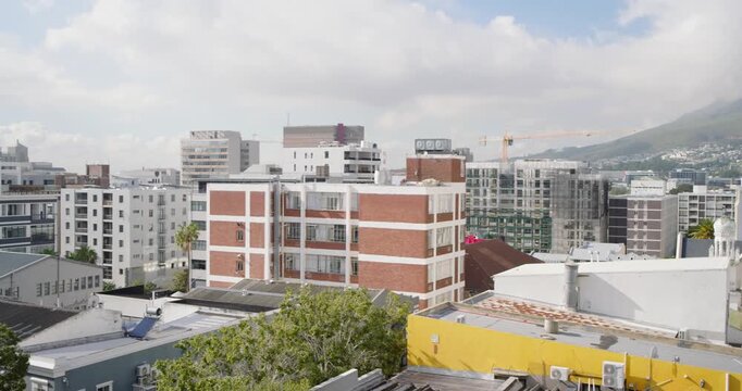 Camera is starting slow left pan on rooftop, holding red brick block centered and revealing skyline