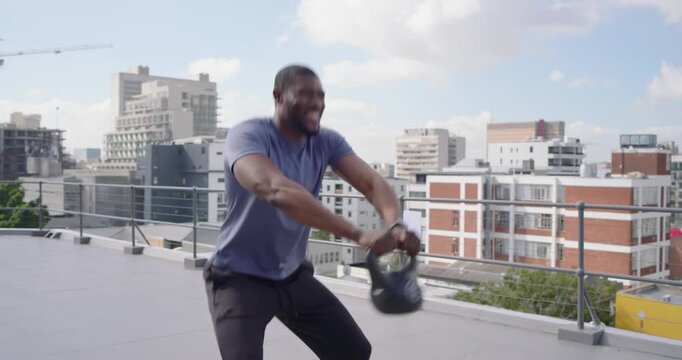Adult African man checking watch, starting kettlebell swings for fitness in blue shirt on roof