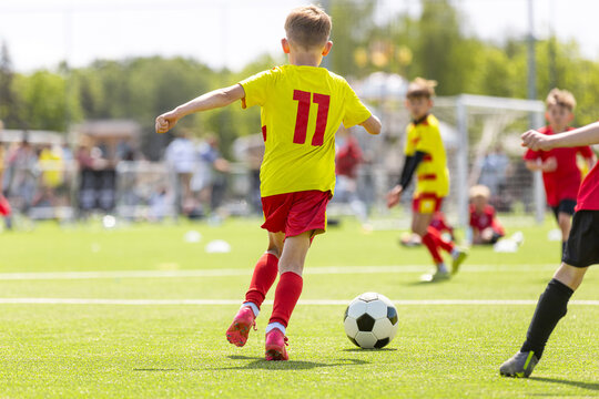 Young Soccer Player Number 11 Taking Shot: Kids Football Match Action on Field