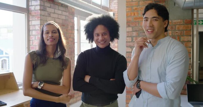 Diverse coworkers laughing, exchanging smiles, turning to camera while posing and checking watches