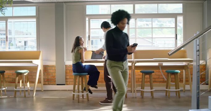 Diverse team walking in loft, high-fiving, leaning, opening laptop and collaborating using phone