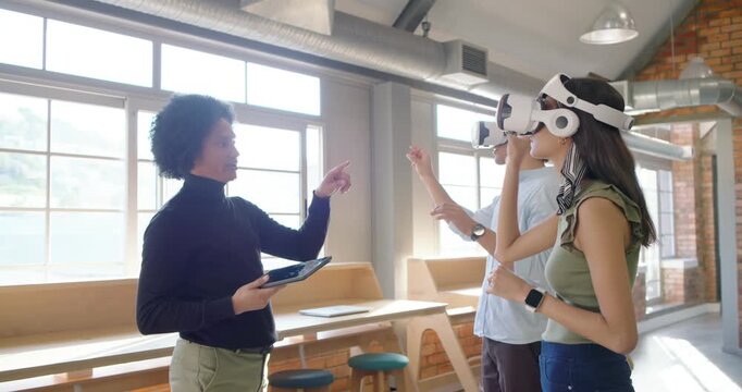 Instructor guiding trainees via tablet, trainees pinching, pointing with white VR headsets for demo