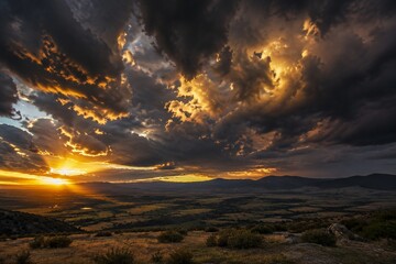 Obraz premium Dramatic sky before a storm with heavy clouds edged in golden sunset light.