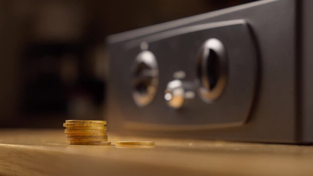 Hand Placing a Stack of Gold Coins into a Safe, Saving Money Concept