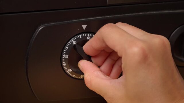 Hand turns dial on secure safe