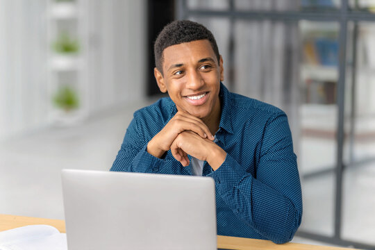 Smiling black man working on laptop office