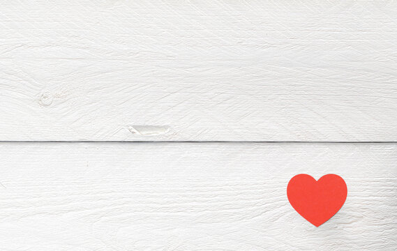 Red paper heart on white wooden background