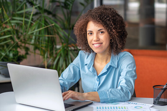 Smiling African American businesswoman working on laptop