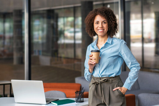 Smiling African American corporate worker holding coffee