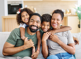 Fototapeta premium Portrait of a happy black family mother father and kids at home on couch
